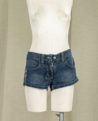 a mannequin on a mannequin stand in front of a curtain