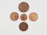 a group of five different coins sitting on top of a white surface