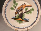 a plate with a bird painted on it on a table