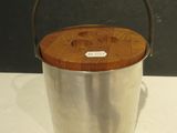 a metal bucket with a wooden lid on a table