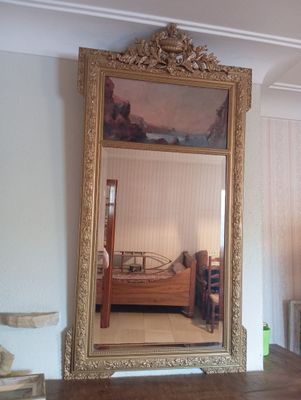 un grand miroir au milieu d'une chambre où se trouve un lit
