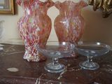 trois vases en verre posés sur une table à côté d'un miroir
