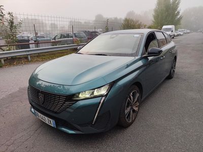 La voiture verte est garée sur le bord de la route, dans le brouillard.