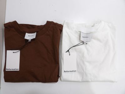 two white and brown t - shirts sitting next to each other on a table