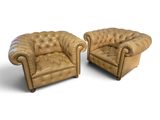 deux chaises en cuir marron assises l'une à côté de l'autre sur une surface blanche