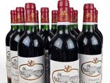six bottles of red wine lined up in a row on a white surface