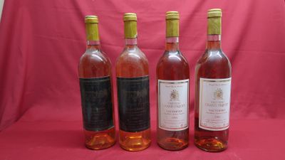 four bottles of wine are lined up on a pink background