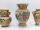 three vases are sitting next to each other on a white surface