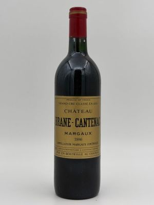 the bottle of wine is sitting on a white surface