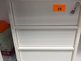 a white cabinet with three drawers and a key on it