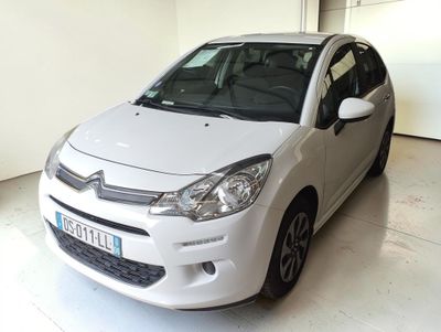 une petite voiture blanche garée dans un garage