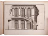someone holding a book open to a drawing of a building