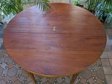 a round table with a wooden top on a tiled floor