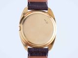 a close up of a gold watch with a brown leather strap