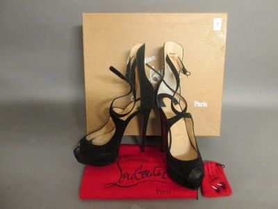 des chaussures à talons hauts noires et blanches, avec une boîte rouge posée sur une table