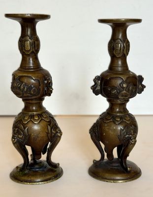 deux vases en bronze posés l'un à côté de l'autre sur une table