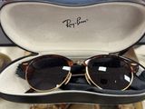 Des lunettes de soleil Ray-Ban à motif écaille, présentées dans un étui, exposées dans un magasin
