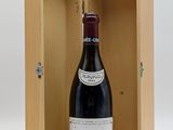 an open wooden box with a bottle of wine inside of it