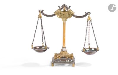 a gold scale with two silver bowls on it