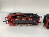 two toy trains sitting side by side on a white surface