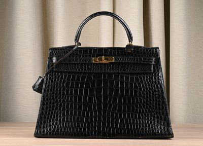 a black crocodile skin handbag on a wooden table
