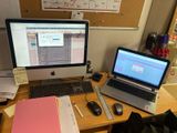 un bureau sur lequel se trouvent un ordinateur, un clavier, une souris et un cahier