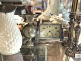 une vitrine sur laquelle sont posés une horloge et un vase