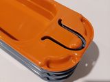 an orange plastic tray with a handle on a white table