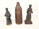 three wooden figurines of a woman and two men