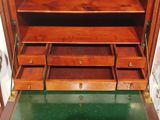 a wooden cabinet with drawers and a green floor