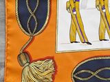 an orange and blue scarf with a picture of two men in uniform