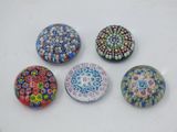 six glass magnets with different designs on them on a white surface