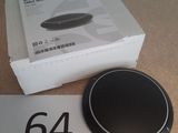 une enceinte noire posée sur une table, à côté d'une boîte