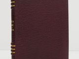 a burgundy leather book with gold trims and a gold stripe on the cover