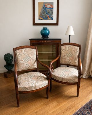 deux chaises dans un coin d'une pièce, avec un vase bleu sur la table