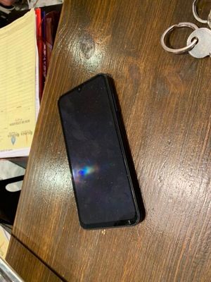 un téléphone portable posé sur une table, à côté d'un stylo et d'une feuille de papier