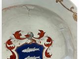 a white plate with a blue and red crest on it