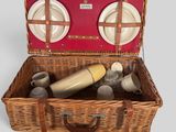 a wicker picnic basket with plates and cups in it