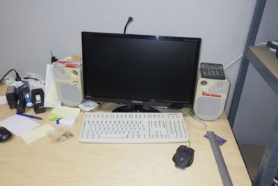 un bureau sur lequel se trouvent un ordinateur, un clavier, une souris et d'autres objets