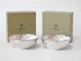 two silver bowls sitting next to each other in front of a box
