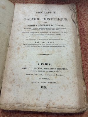 un vieux livre posé sur une table à côté d'une tasse de café
