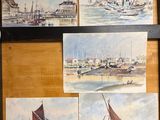 several paintings of boats are hanging on a wall in a room