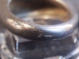 a close up of a silver ring on a silver plate