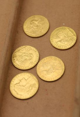 plusieurs pièces d'or posées sur une boîte en carton