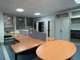 une pièce équipée d'une table, de chaises et d'un réfrigérateur