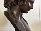 a bronze bust of a young man with curly hair