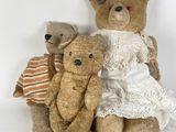 three teddy bears sitting next to each other on a white surface