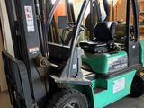 un chariot élévateur vert garé dans un garage
