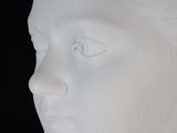 a white sculpture of a woman ' s head on a black background