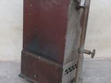 a small metal stove sitting on the sidewalk